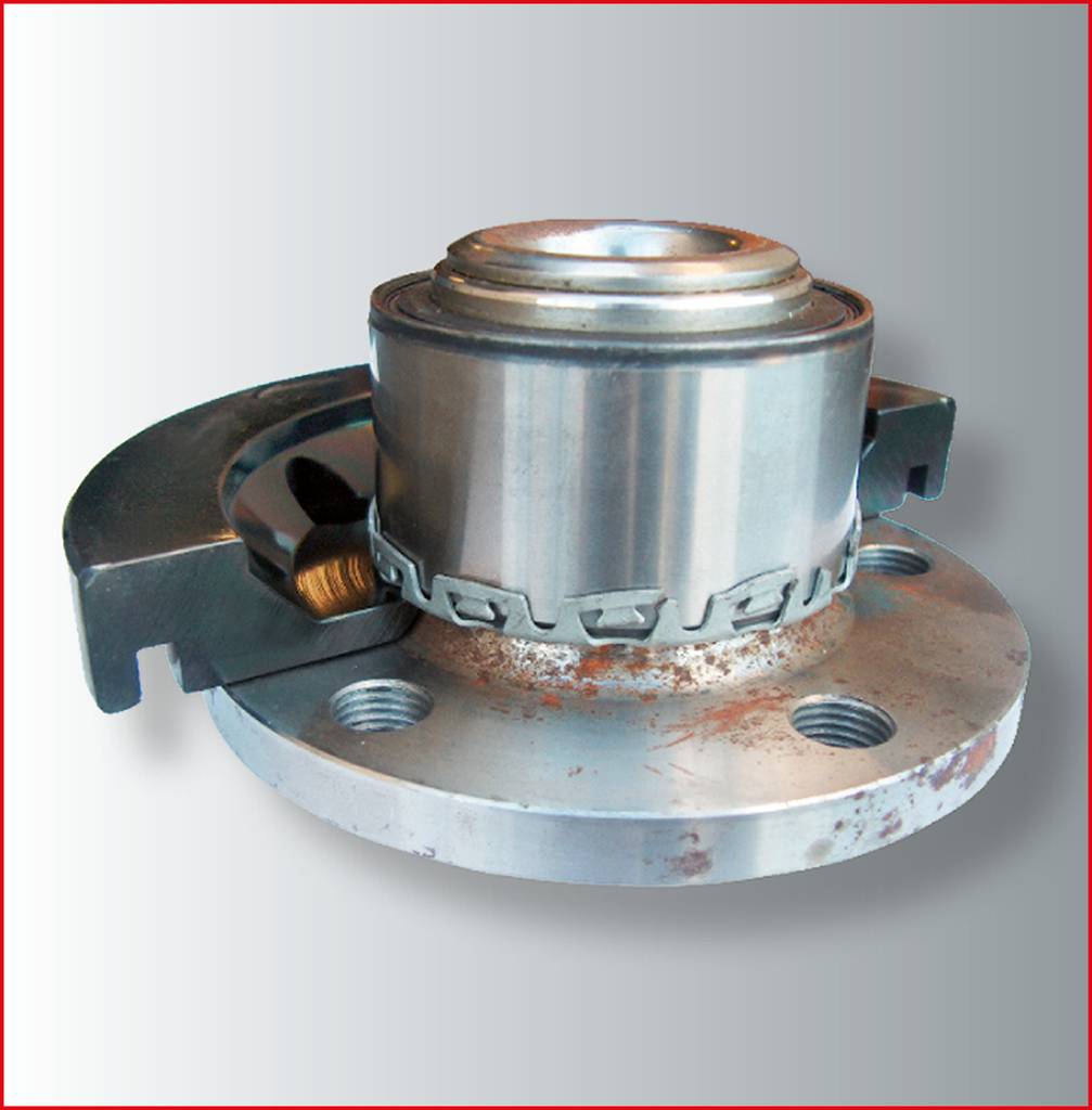 Zardzewiała metalowa część z kulistym elementem pośrodku, zamontowana na okrągłej podstawie, wykazuje ślady użytkowania i zużycia.