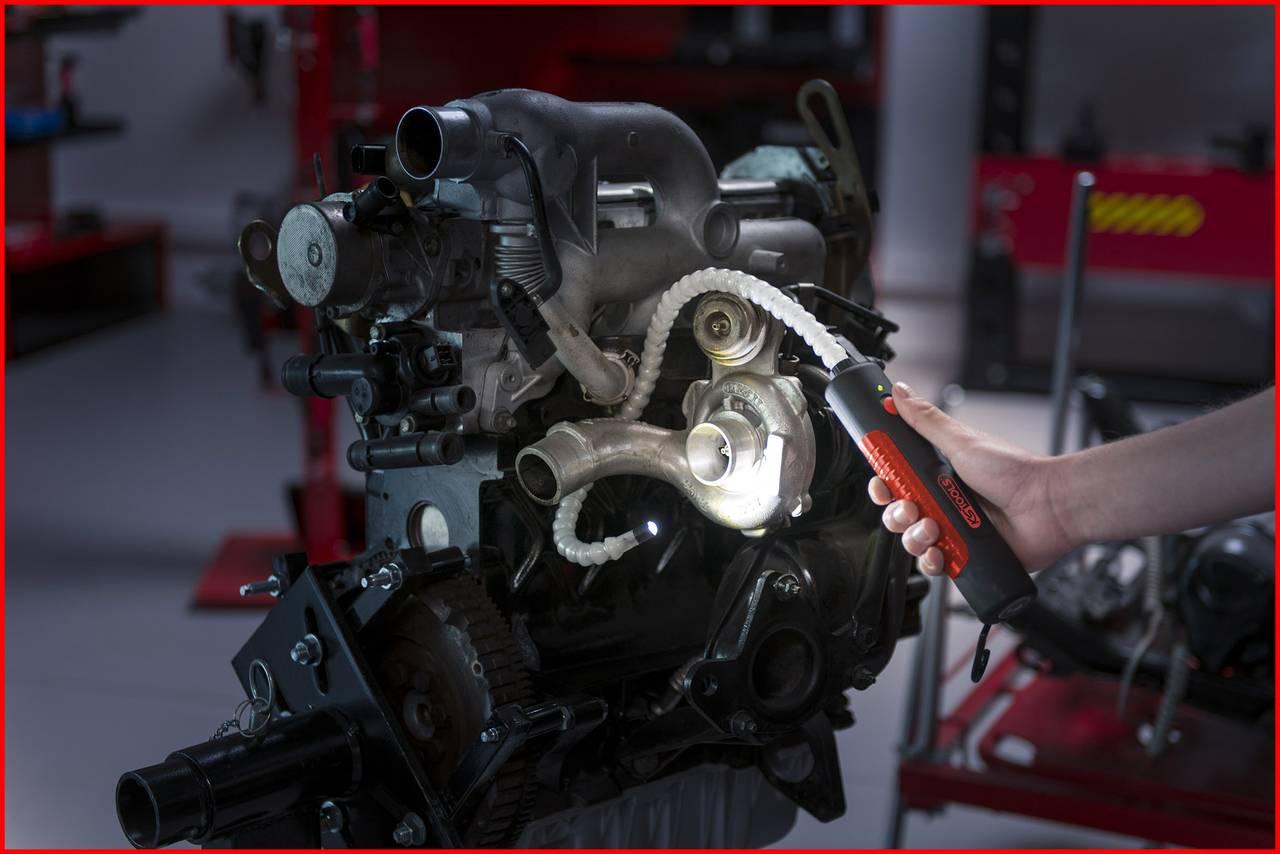 Urządzenie techniczne, którego elementy są oświetlane lampą. Jedna osoba trzyma lampę, aby uczynić widocznymi szczegóły.