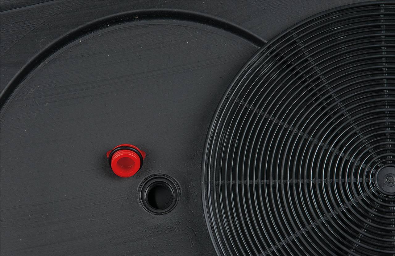 Czarna płyta indukcyjna, czerwony pokrętło po lewej stronie, okrągła czarna cewka po prawej stronie do równomiernego rozłożenia ciepła.