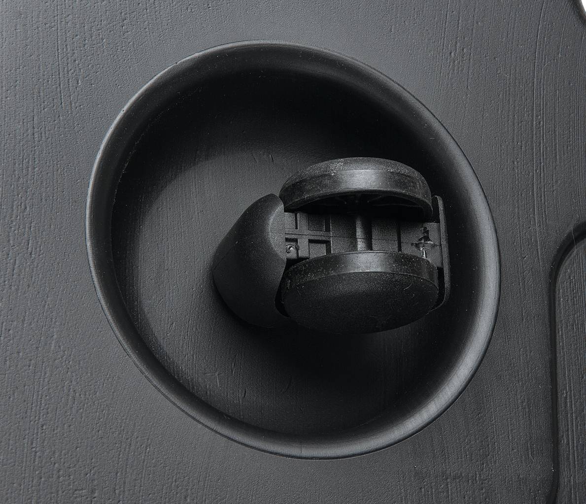 Zbliżenie czarnego plastikowego pokrętła umieszczonego w okrągłym zagłębieniu. Może być elementem urządzenia lub maszyny.