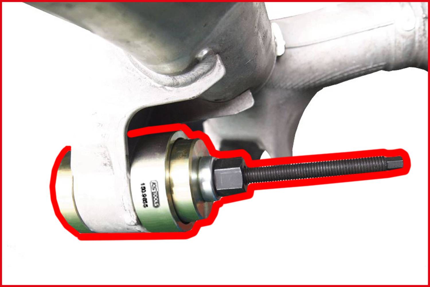 Specjalistyczne narzędzie warsztatowe służy do wyciągania łożyska z zawieszenia koła. Narzędzie obejmuje długą śrubę.