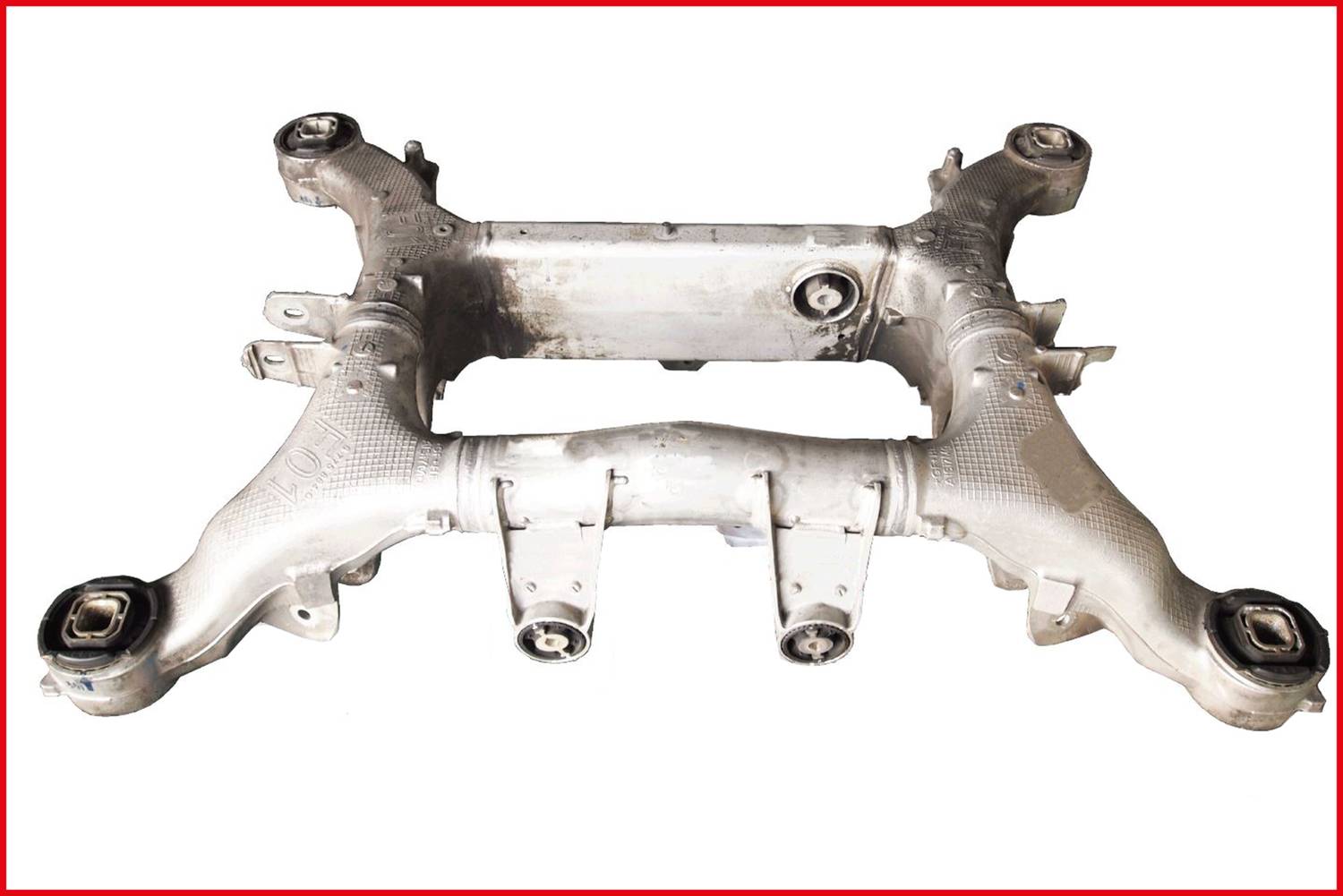 'Aluminiowy nośnik osi z wieloma punktami mocowania i charakterystycznymi strukturami, typowy dla montażu pojazdów.'