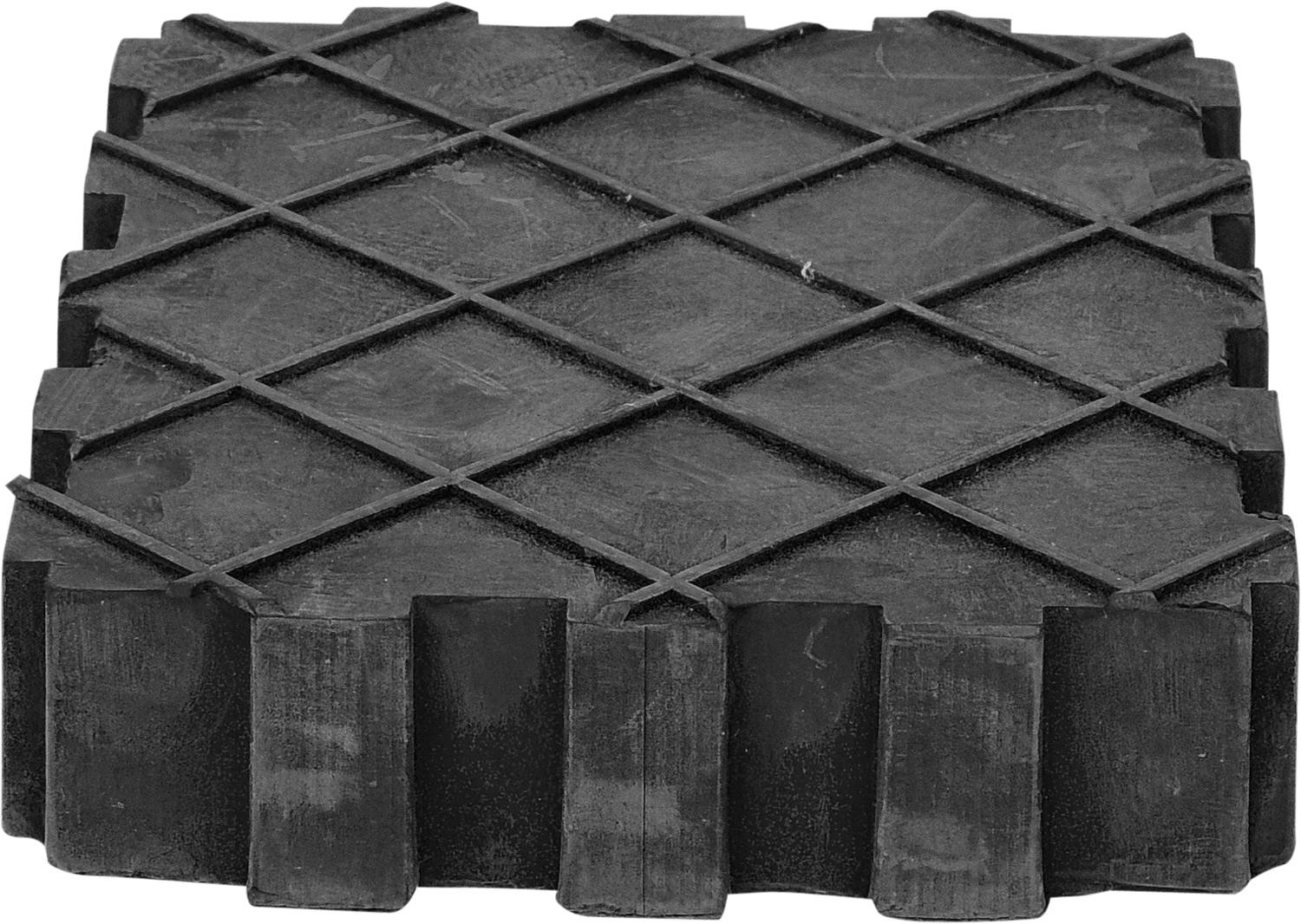 Kwadratowy, żebrowany blok gumowy o antypoślizgowej strukturze, prawdopodobnie przeznaczony do stabilizacji lub podpierania pojazdów.