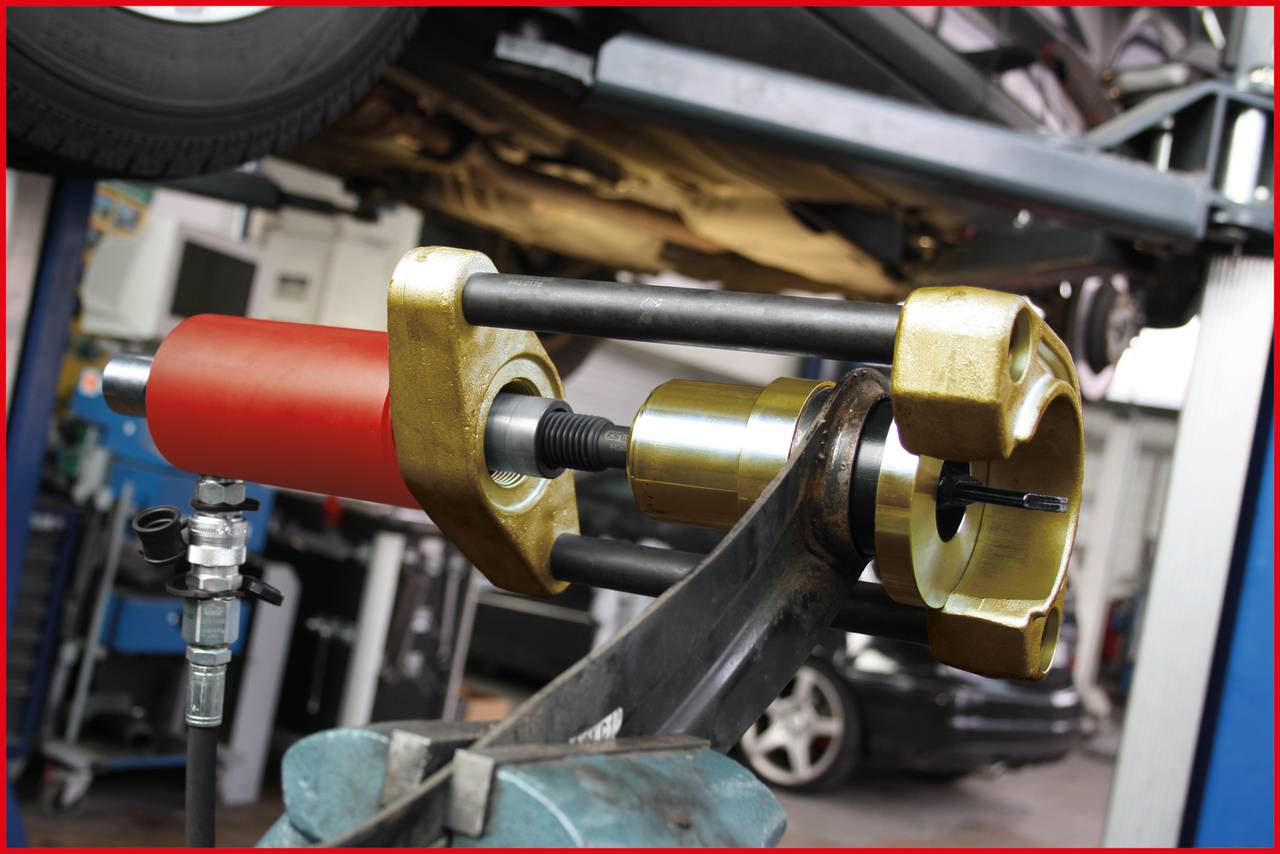 Maszyna w warsztacie podnosi samochód.