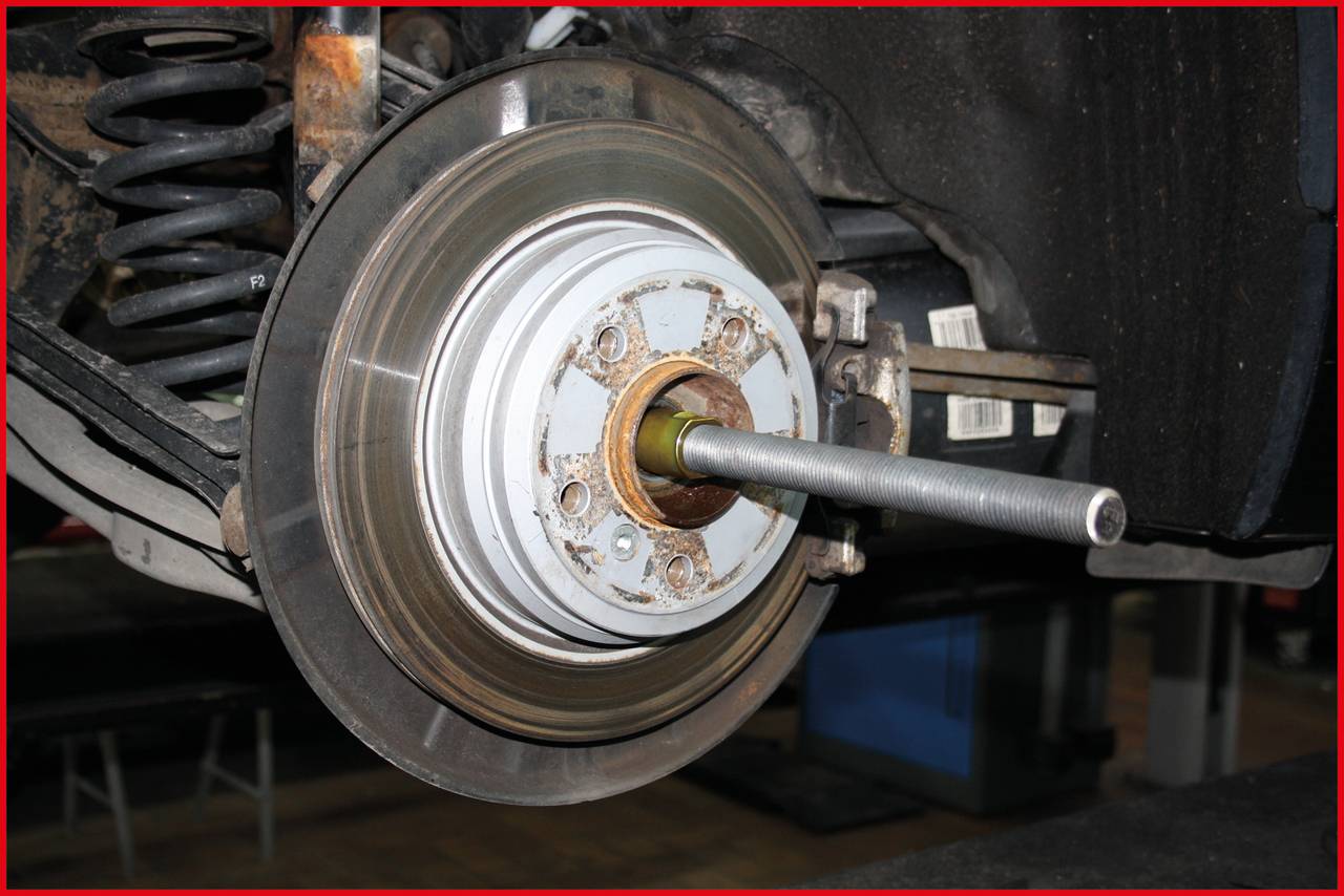 Zbliżenie tarczy hamulcowej i piasty koła pojazdu. Tarcza hamulcowa jest zużyta, a piasta koła wykazuje ślady rdzy.