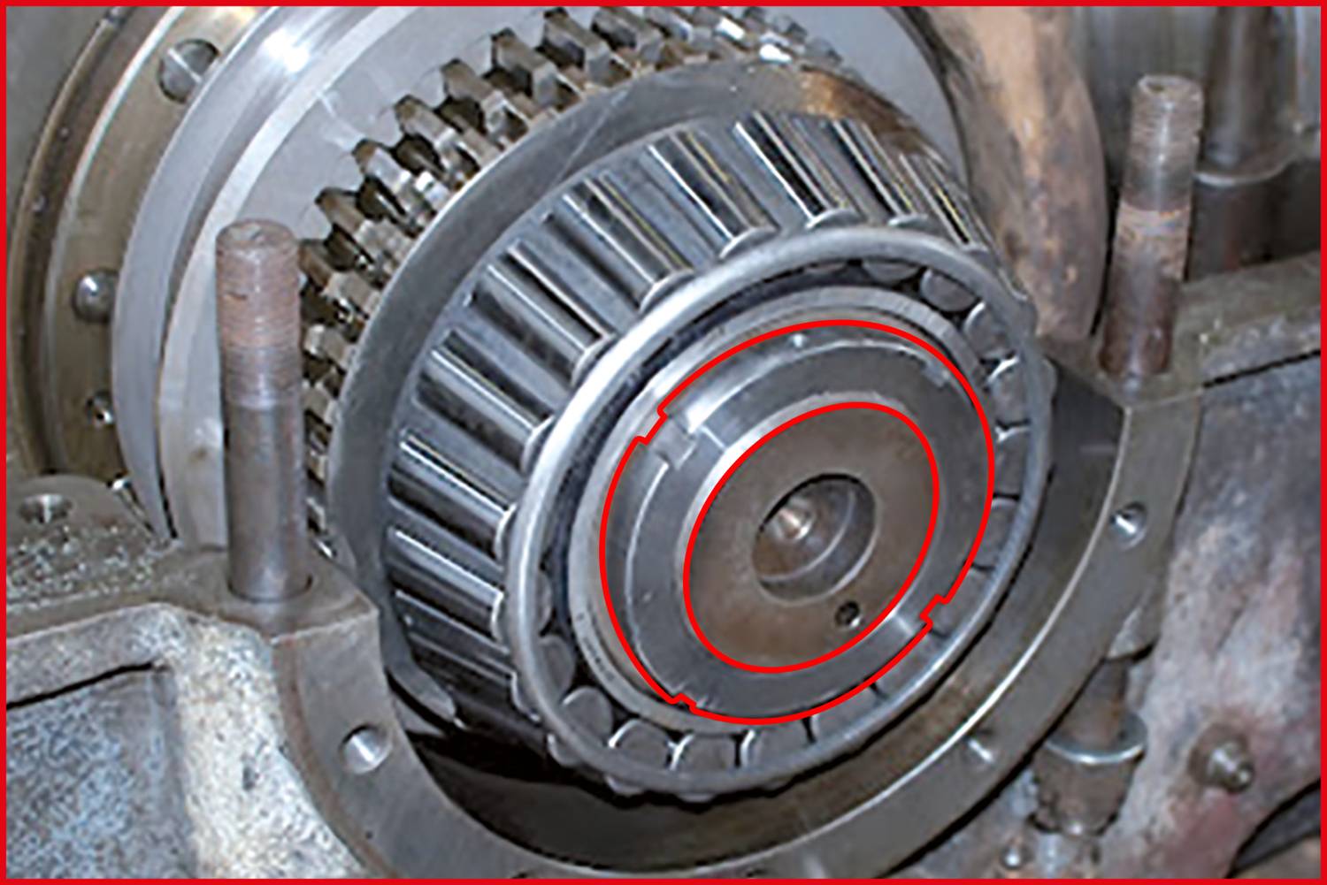 Zbliżenie złożonego metalowego koła zębatego w maszynie. Wyraźnie widoczne zęby i koła podkreślające wybrane obszary.