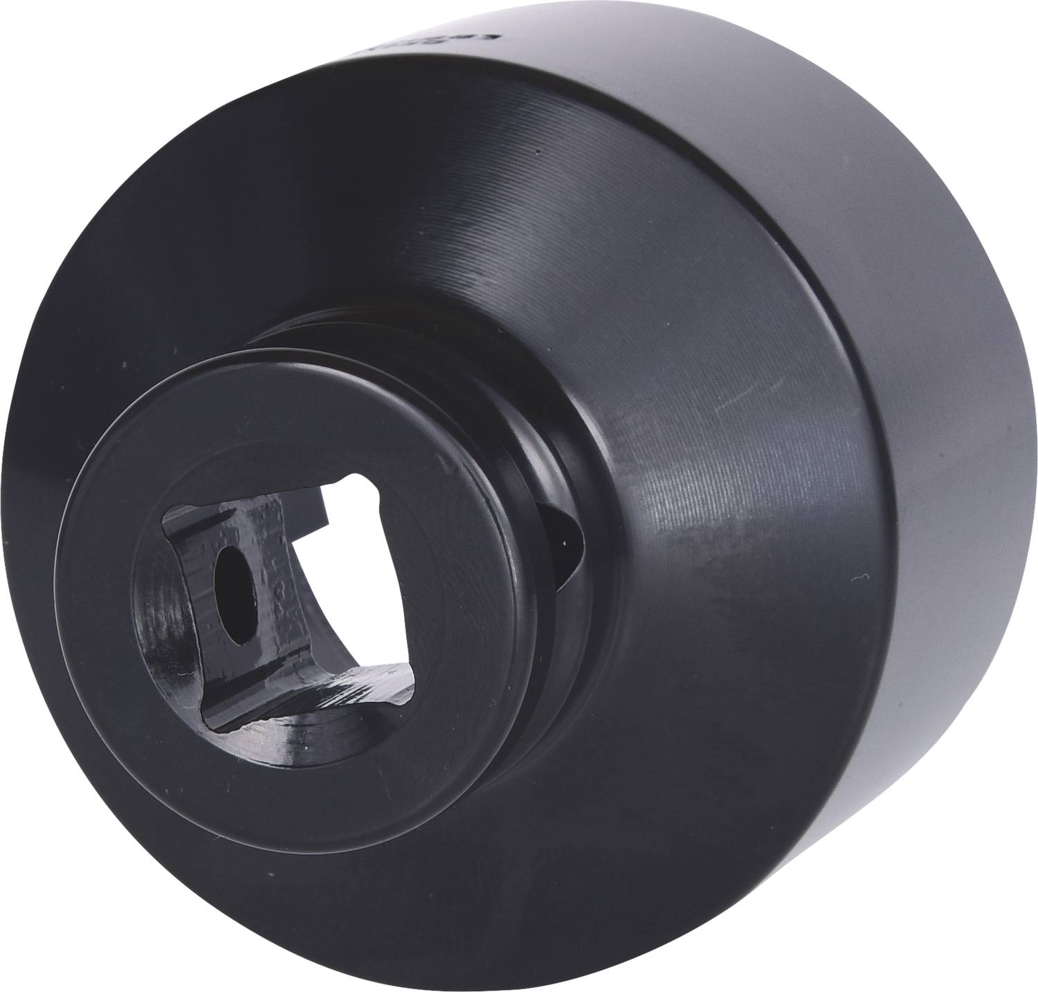 Czarna, okrągła metalowa część z centralnym kwadratowym otworem. Może to być element maszyny lub nasadka narzędziowa.