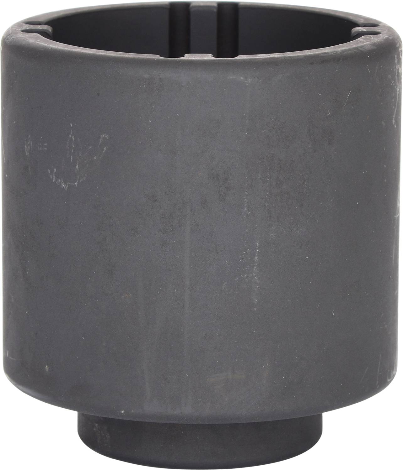 Masywny, cylindryczny element metalowy o jednolicie szarej powierzchni, prawdopodobnie część maszyny lub pojazdu.