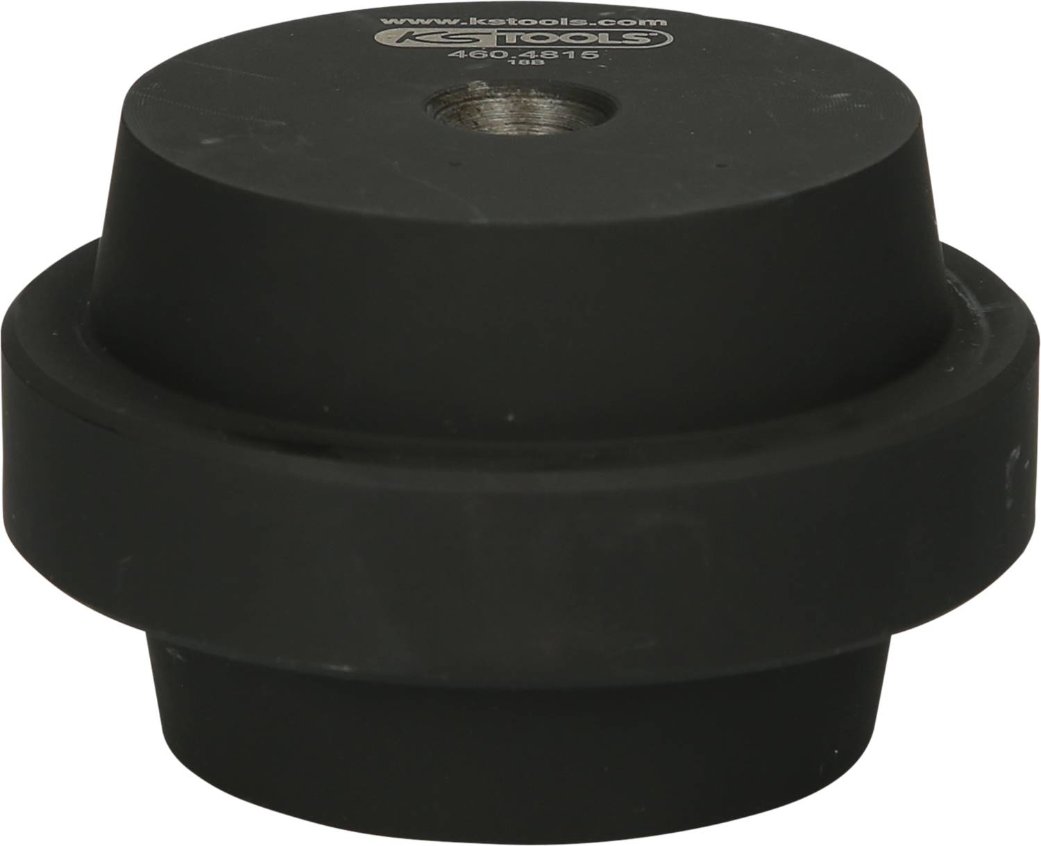 'Czarne okrągłe metalowe narzędzie z centralnym gwintem, używane do prac mechanicznych. Solidna i prosta konstrukcja.'