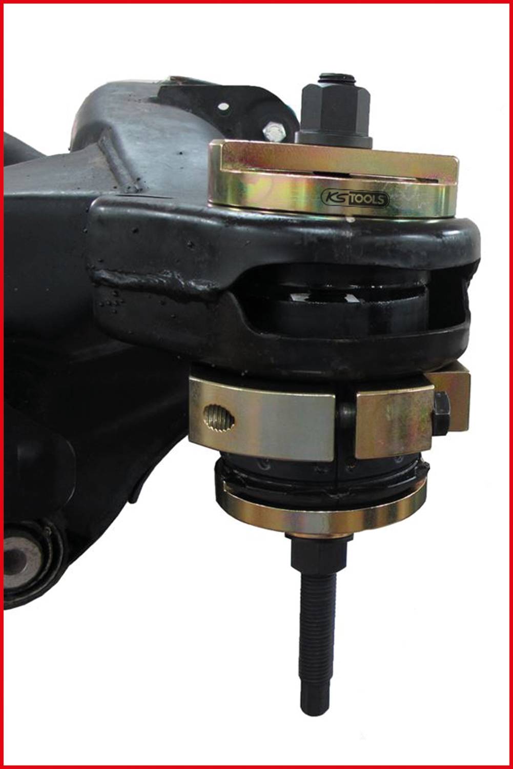 Ściągacz sworznia wahacza zamontowany na części samochodowej. Prezentuje specjalny mechanizm bezpiecznego demontażu sworzni wahacza.