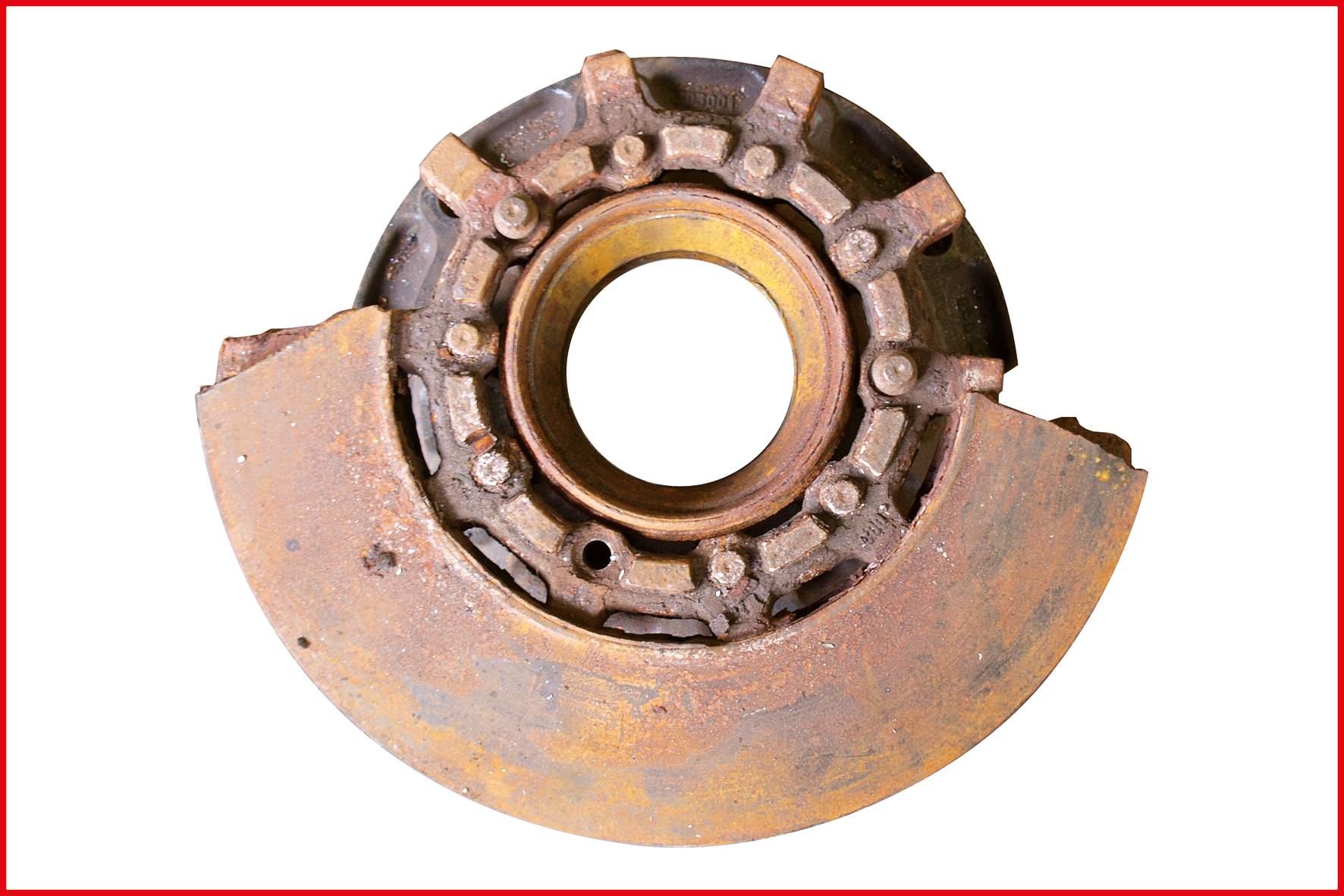 Zardzewiały element maszynowy z strukturami przypominającymi koło zębate oraz elementem o kształcie półkola.