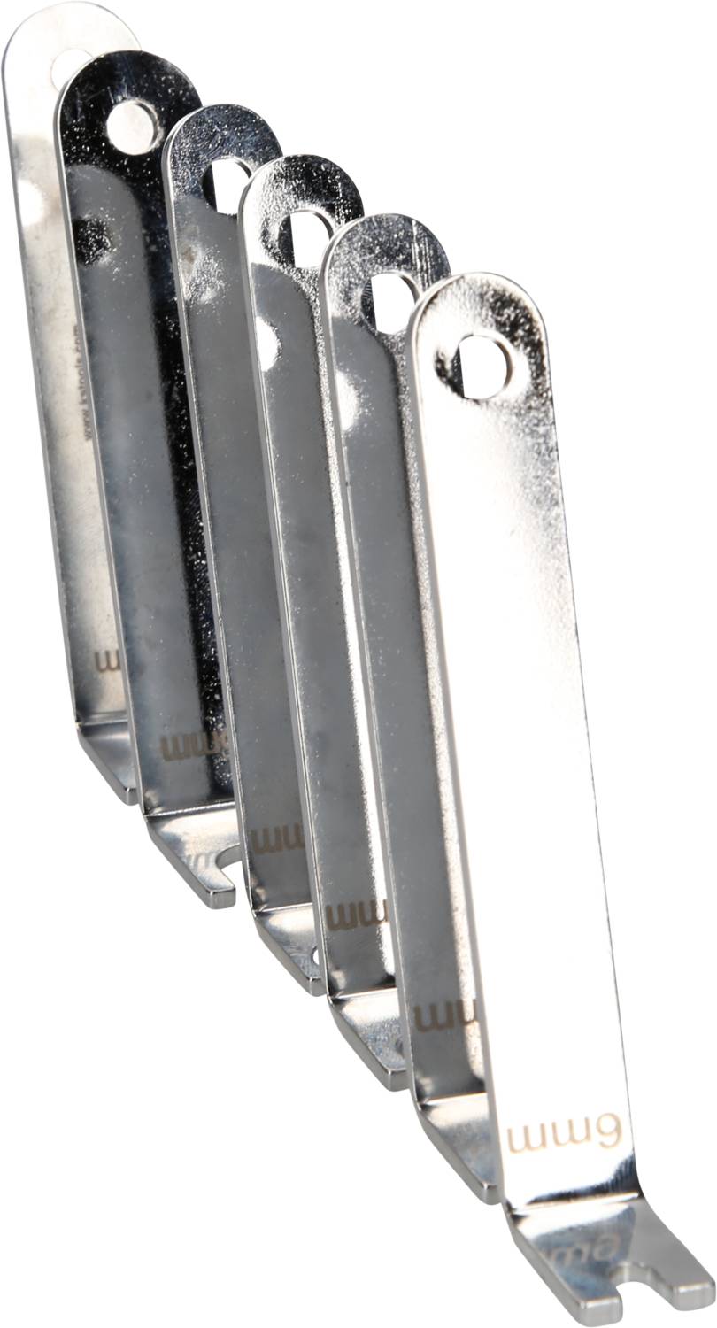 Pięć chromowanych przełączników bezpieczeństwa kluczowych w rozmieszczeniu kaskadowym, każdy z owalnym otworem na jednym końcu i grawerunkiem '9 mm'.