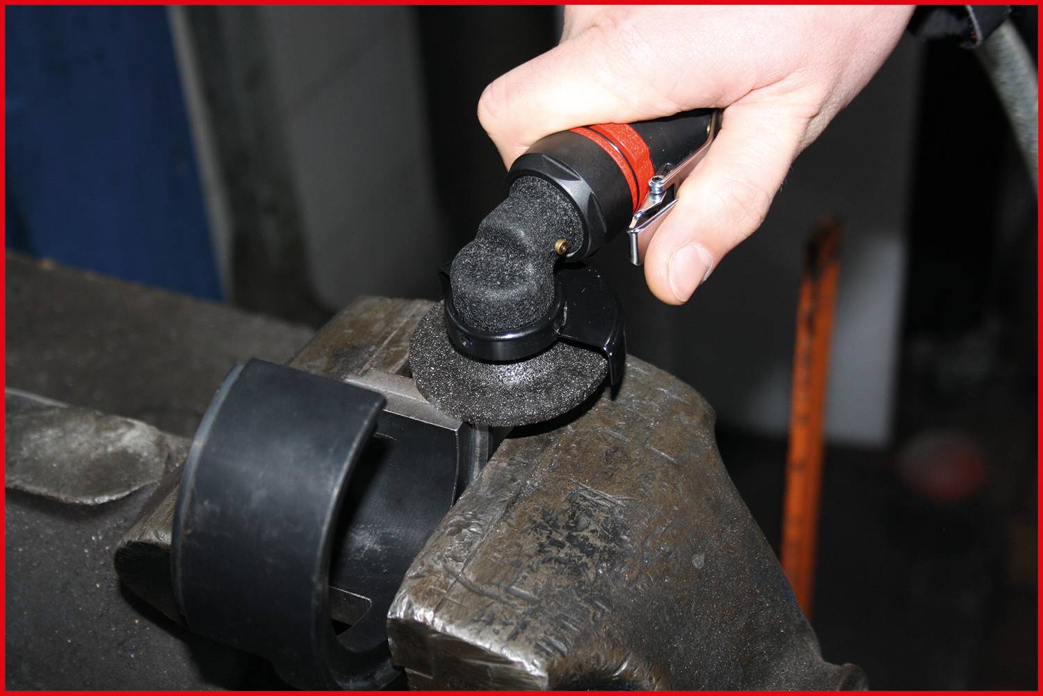 Osoba szlifuje metalową powierzchnię elektronarzędziem, aby wygładzić ją lub usunąć nadmiar materiału.