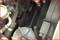 Zbliżenie silnika samochodowego, prezentujące pasek klinowy i otaczające go komponenty. Dłoń trzyma narzędzie nad silnikiem.