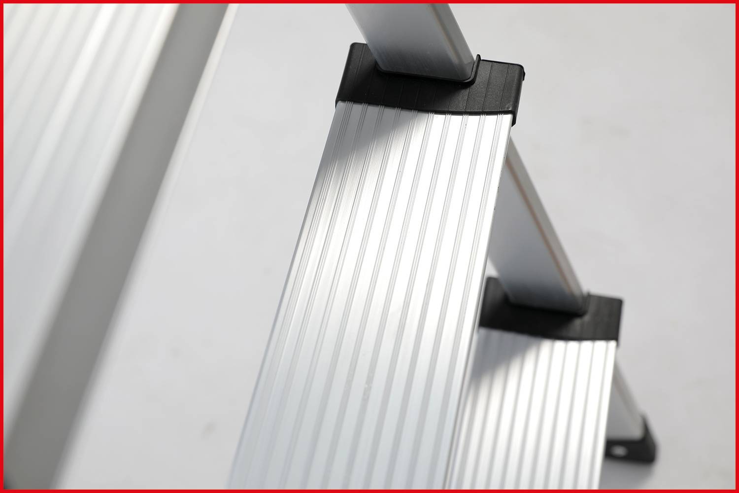 Metalowe stopnie drabiny z antypoślizgową powierzchnią, widziane z boku.