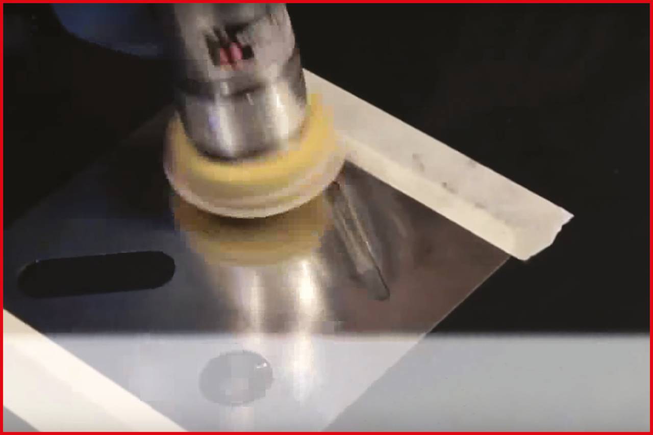 Maszyna polerska poleruje powierzchnię metalową przyklejoną taśmą klejącą; wytwarza błyszczące wykończenie.