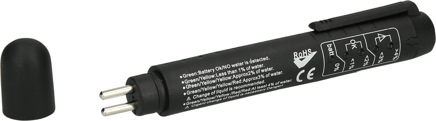 Czarny tester baterii z odkrytą pokrywą, przedstawiający bieguny dodatnie i ujemne. Na urządzeniu widoczne są symbole i instrukcje użycia.