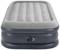 Dmuchany materac w kolorze szarym i ciemnoniebieskim z wbudowanym zaworem pompującym, odpowiedni do użytku wewnątrz pomieszczeń.