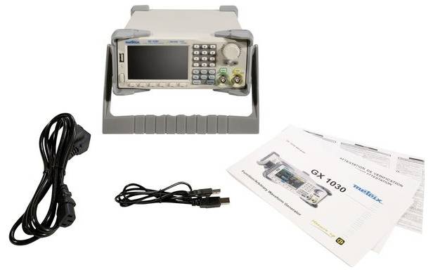 Elektroniczny przyrząd pomiarowy z akcesoriami, w tym przewodem zasilającym, kablem USB i instrukcją obsługi, na stole.