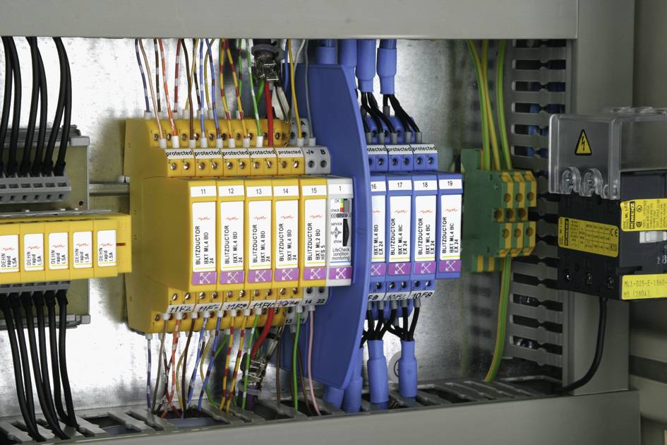 Elektryczny rozdzielnik elektryczny z różnokolorowymi bezpiecznikami i kablami ułożonymi w uporządkowany sposób.