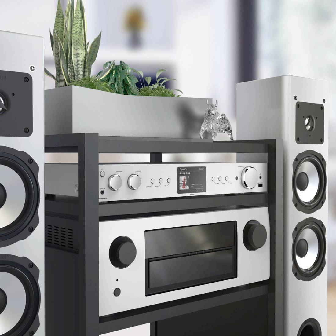 Zestaw stereo z dwoma głośnikami, wzmacniaczem i kompozycją roślinną na regale. Salon w tle.