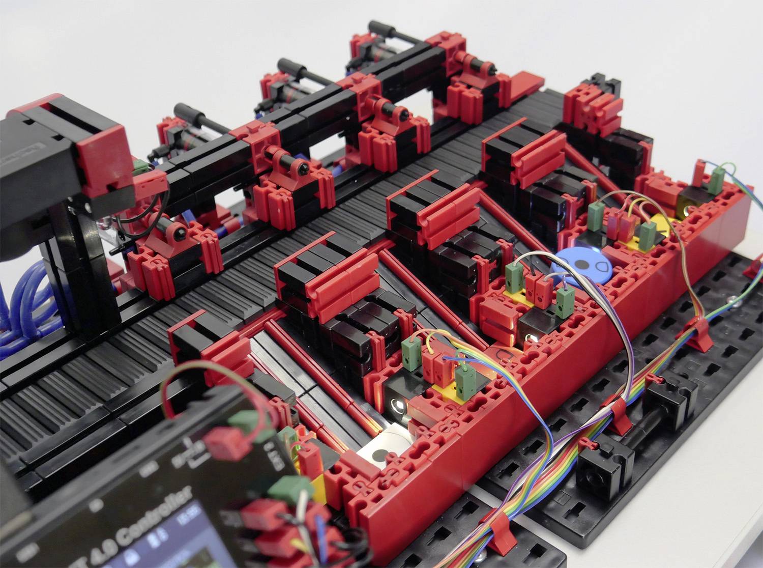 Złożone urządzenie techniczne z czerwonymi i czarnymi elementami, połączonymi kolorowymi przewodami.