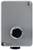 Prostokątna, szara obudowa z okrągłym, czarnym otworem pośrodku. Dwie śruby u góry i jedna na dole.