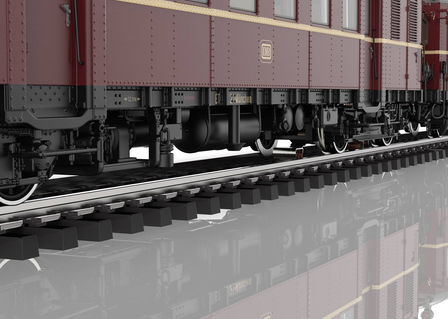 Zbliżenie historycznego wagonu kolejowego na torach, pomalowanego na ciemnoczerwony kolor, z dokładnym widokiem dolnej struktury wagonu.