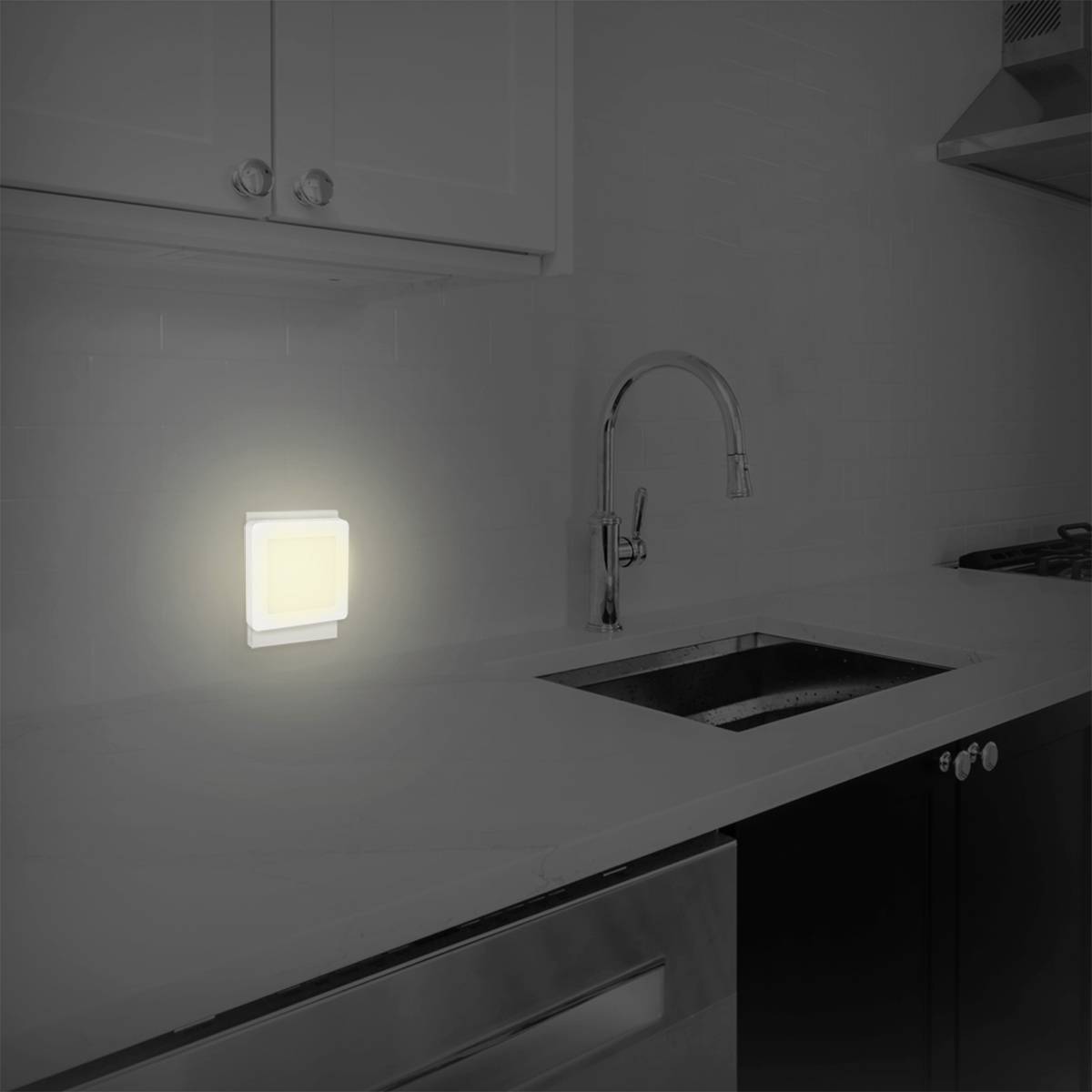 Oświetlona lampa LED na ścianie kuchni doświetla powierzchnię roboczą. W zasięgu wzroku znajduje się również zlewozmywak i kran.