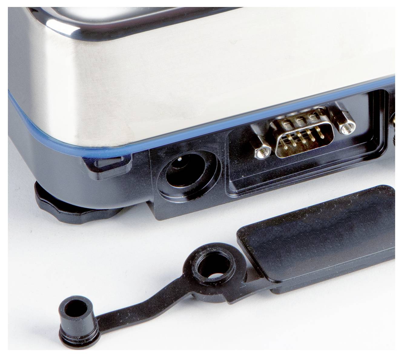 Zbliżenie elektronicznego urządzenia z odkrytym złączem szeregowym i zdjętą plastikową pokrywą.