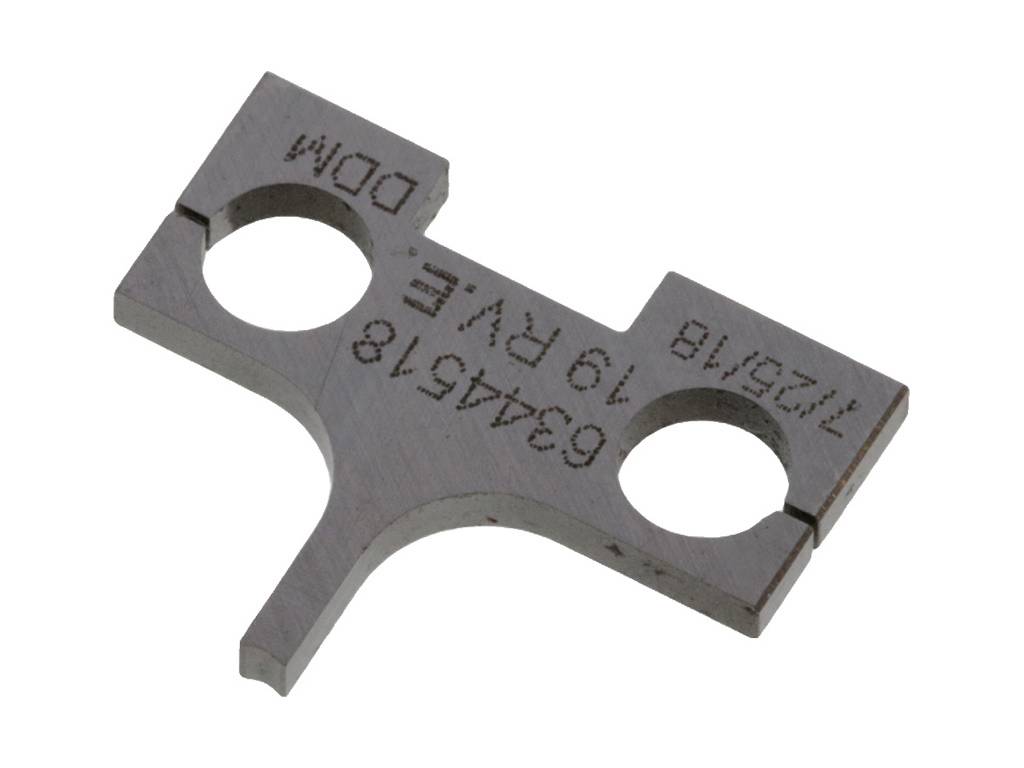 Metalowy element łączący z dwiema okrągłymi otworami, jedną płaską krawędzią oraz wygrawerowanymi numerami seryjnymi i literami.