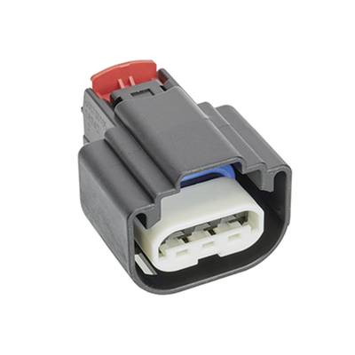 Czarny elektryczny złącz z czerwonym i niebieskim elementem, przedstawiający trzy styki przyłączeniowe, prawdopodobnie przeznaczone do zastosowań w pojazdach.