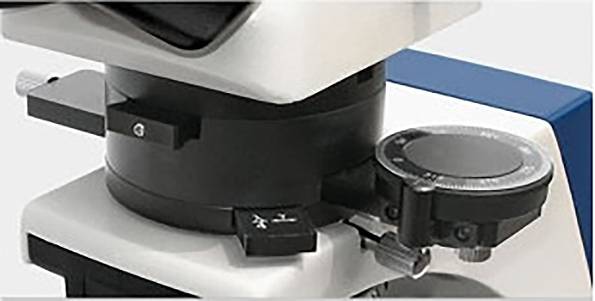 Mikroskop w zbliżeniu, ukazujący szczegóły głowicy rewolwerowej i mechanizmu ostrości. Niezbędny do badań laboratoryjnych i prac badawczych.