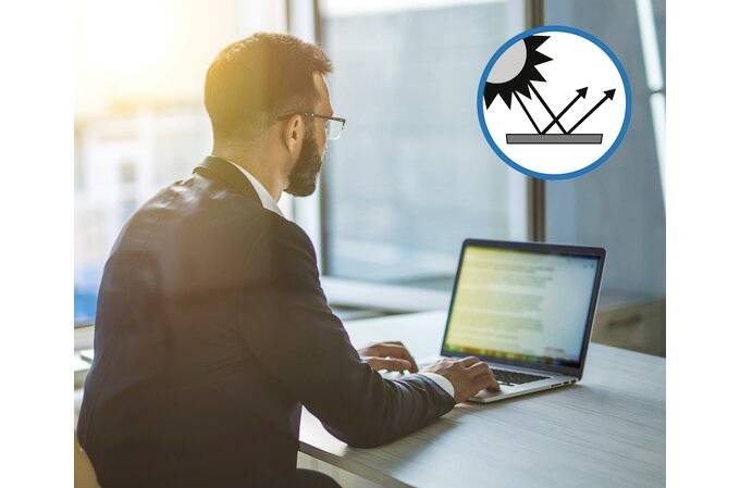 Mężczyzna w garniturze pracuje na laptopie w zallanym słońcem biurze. Obok widoczny jest symbol ochrony przed oślepieniem ekranu.