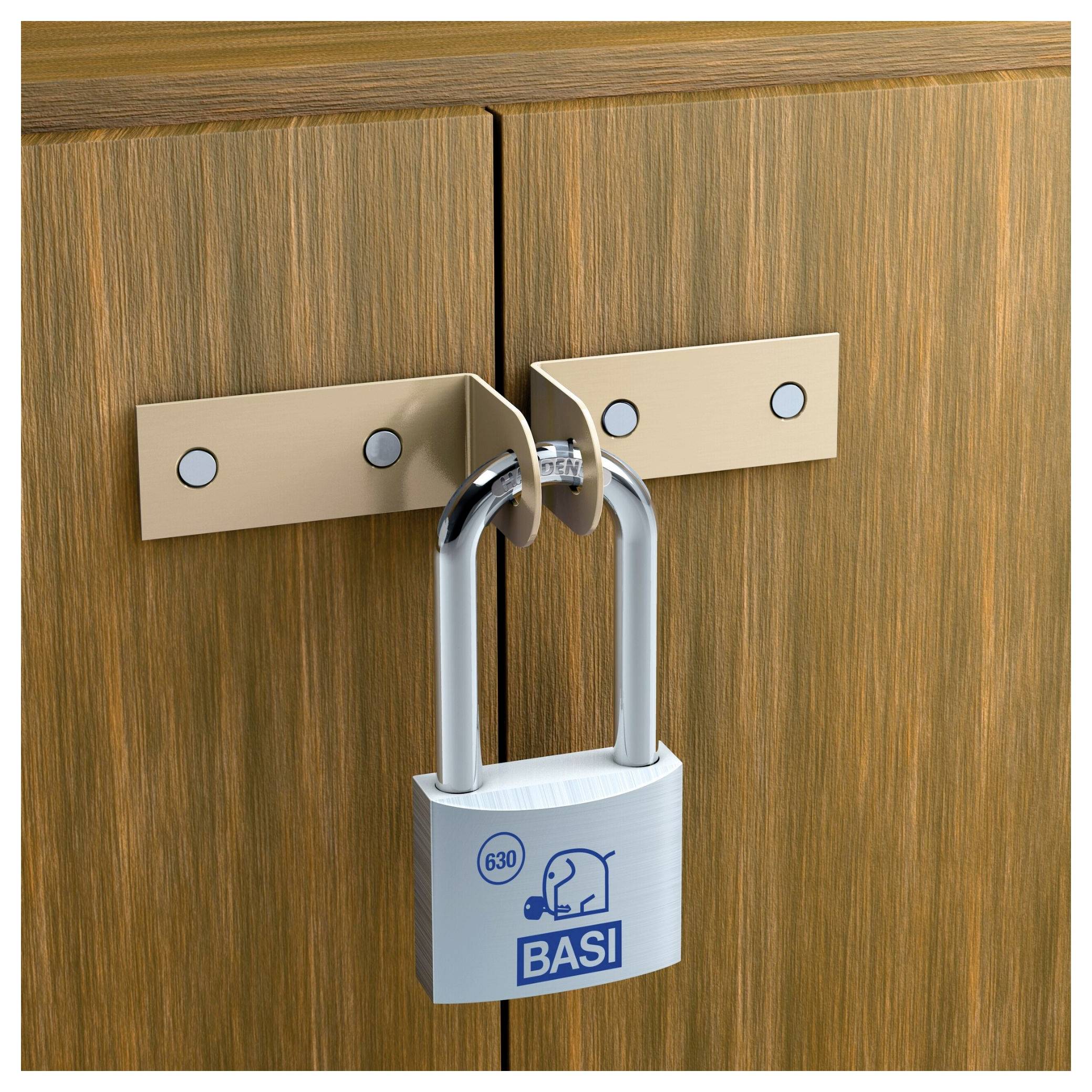 Kłódka na dwóch brązowych drewnianych drzwiach, zabezpieczona metalową poprzeczką, z napisem 'BASI' i wizerunkiem słonia.
