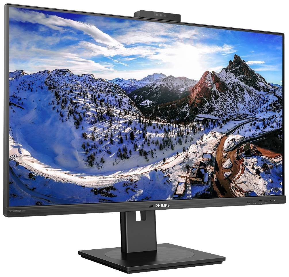 Monitor komputerowy wyświetla ośnieżony krajobraz górski o zachodzie słońca, z czystym, niebieskim niebem i dramatycznymi chmurami.