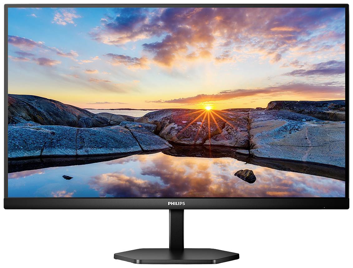 Monitor wyświetla krajobraz przedstawiający zachód słońca nad skalistym brzegiem, którego odbicie widać w wodzie.