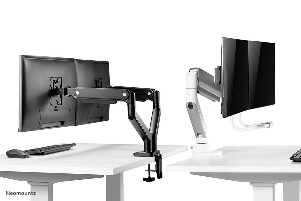 Dwa ramiona monitora na białych biurkach trzymają ekrany pod różnymi kątami. Po lewej stronie jest czarne, po prawej białe.