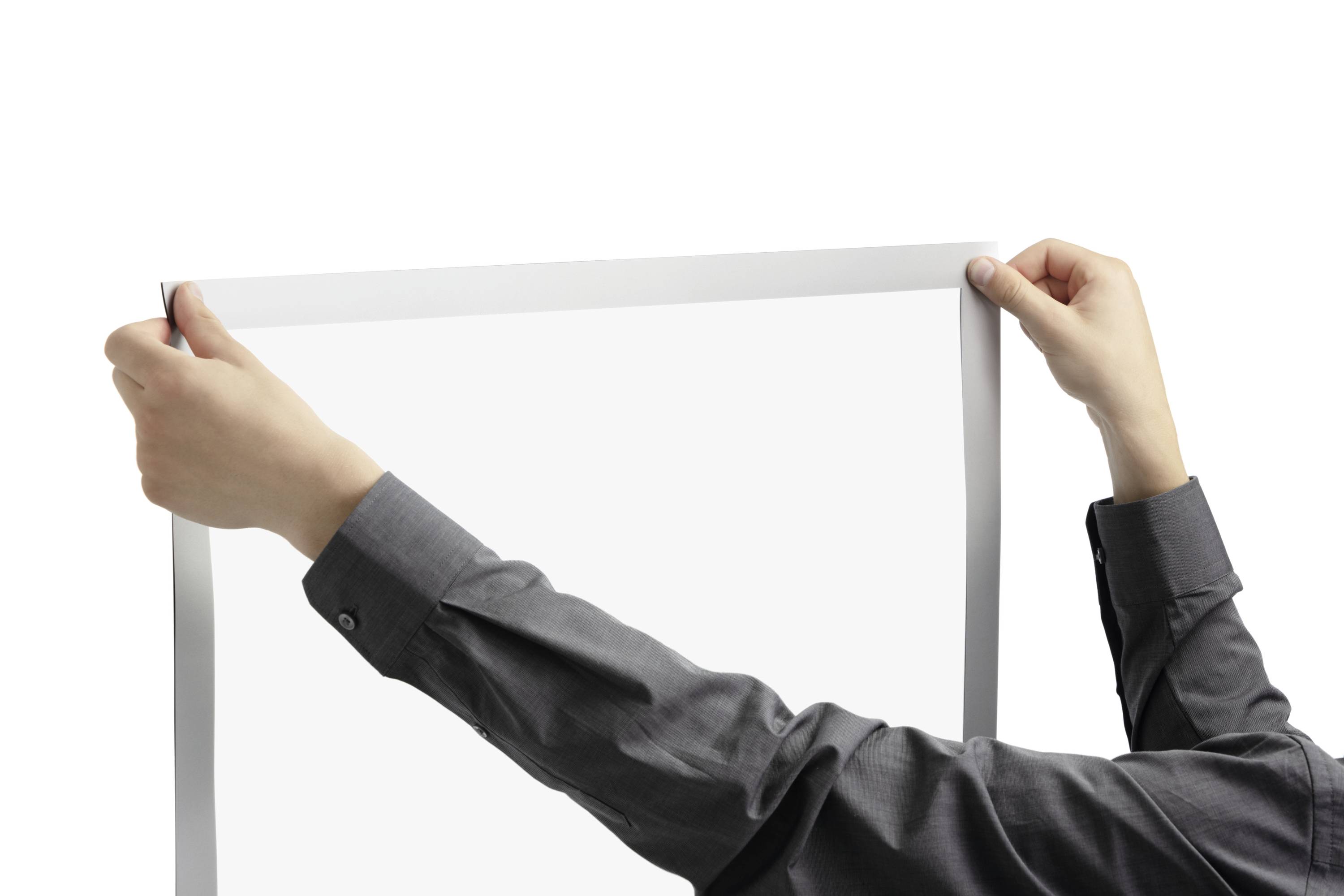 Osoba w szarej koszuli trzyma pusty ramkę na zdjęcia na białym tle.