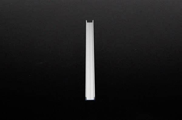 Metalowy obiekt wyśrodkowany pionowo na czarnym tle.