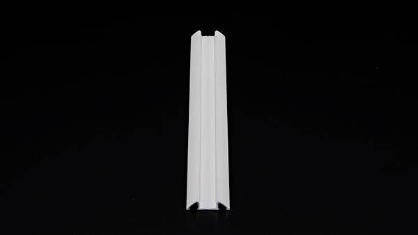 Biały profil z tworzywa sztucznego z rowkiem w kształcie litery V na czarnym tle.