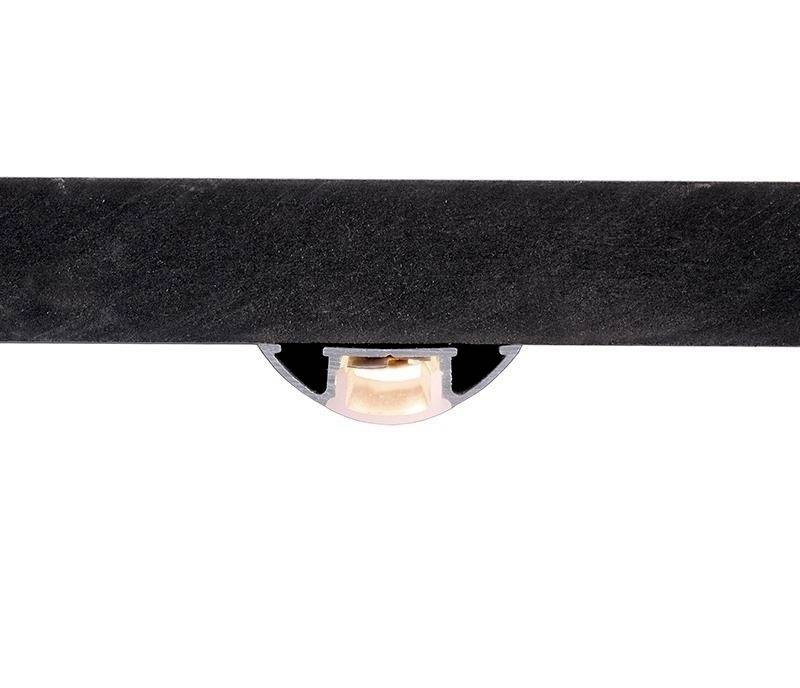 Czarny, poziomy obiekt z otworem w kształcie półkola pośrodku, przez który widać małый, jasny element.