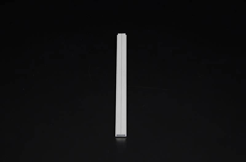 Profil metalowy na czarnym tle, pionowo wyśrodkowany.