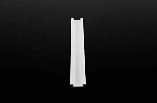 Biała, wąska plastikowa klamerka stoi pionowo na czarnym tle.