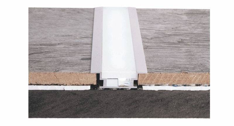 Przekrój pionowy profilu gruntowego z zintegrowanym kanałem kablowym pomiędzy dwiema deskami drewnianymi. Widoczna struktura gruntu oraz mocowanie.