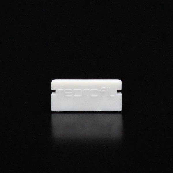 Prosty, prostokątny, biały obiekt na czarnym tle, prawdopodobnie ostrze lub mała część; bez rozpoznawalnych szczegółów.