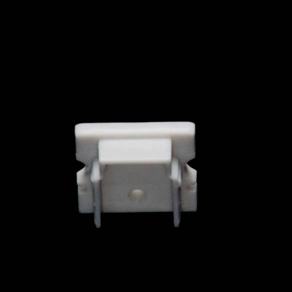 Biały, prostokątny obiekt na czarnym tle, prawdopodobnie element techniczny lub adapter.