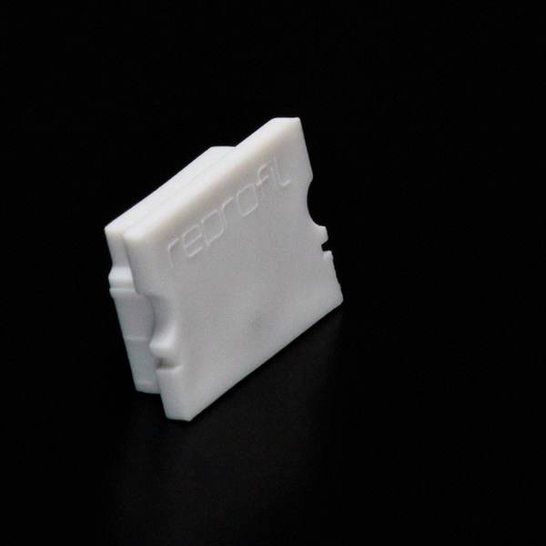 Biały, prostokątny element z tworzywa sztucznego z napisem 'reprofil' na czarnym tle.