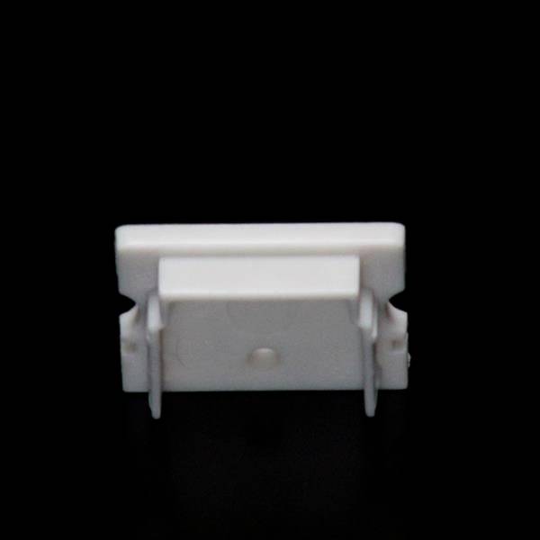 Biały, prostokątny plastikowy klips na czarnym tle; prawdopodobnie służy do mocowania lub organizacji przewodów.
