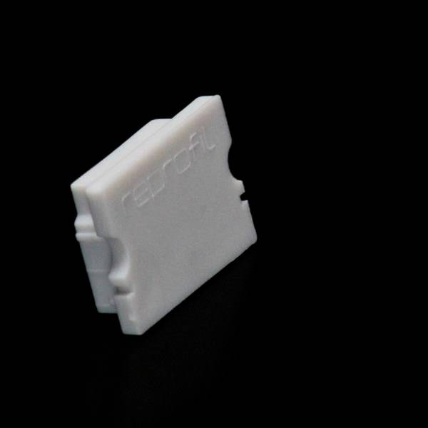 Biały, prostokątny blok z tworzywa sztucznego z napisem 'reproFL' na powierzchni. Blok stoi na czarnej powierzchni.